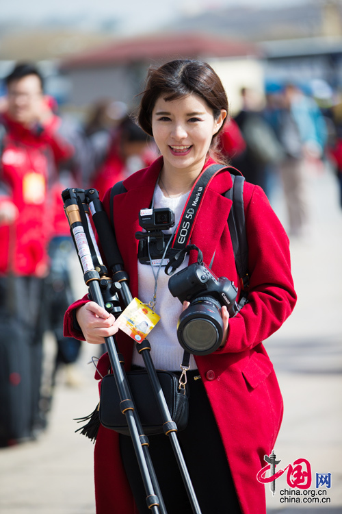 2016年兩會，人民大會大堂前，一位笑容燦爛的紅衣女記者正步入大會堂。中國網(wǎng) 鄭亮 攝