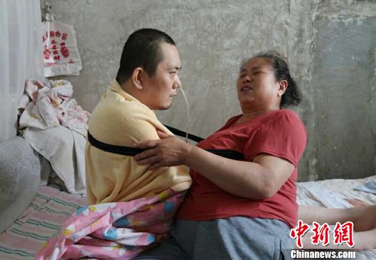 身體日漸衰老的梁青蘭每次幫兒子翻身、坐立，全身的衣物都要濕透一次?！∩忻鱾b 攝