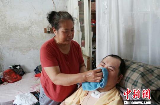 每次喂完食物后，梁青蘭都要仔細(xì)地幫兒子清理干凈。　尚明俠 攝