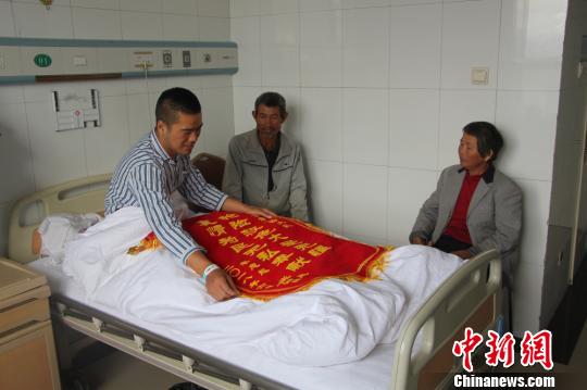 被救的李忠起、張總鳳夫婦看望受傷后的李運(yùn)飛。　汪渝 攝