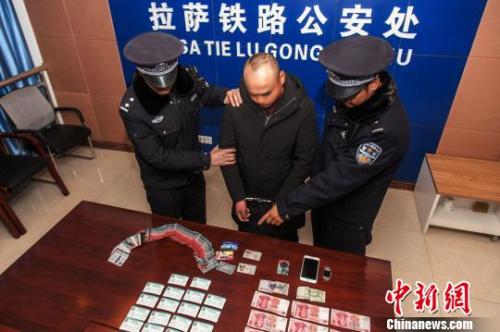 資料圖：一犯罪嫌疑人對拉薩鐵路警方查獲的火車票進行指認。　胡傳鑫 攝