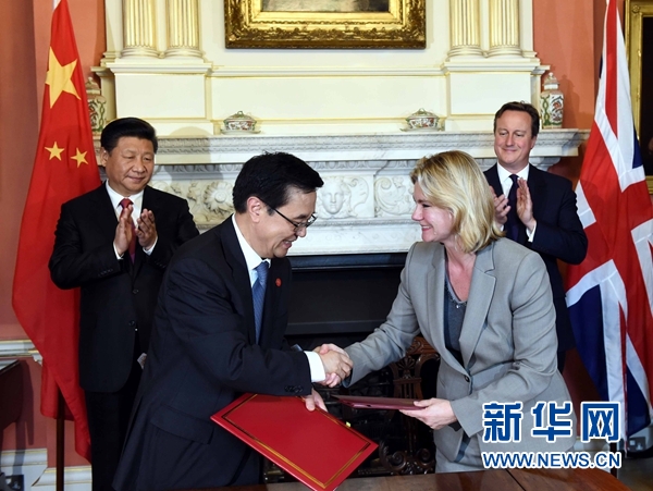 10月21日，國家主席習(xí)近平在倫敦唐寧街首相府同英國首相卡梅倫舉行會談。這是會談結(jié)束后，兩國領(lǐng)導(dǎo)人共同見證雙邊合作文件的簽署。新華社記者 饒愛民 攝 